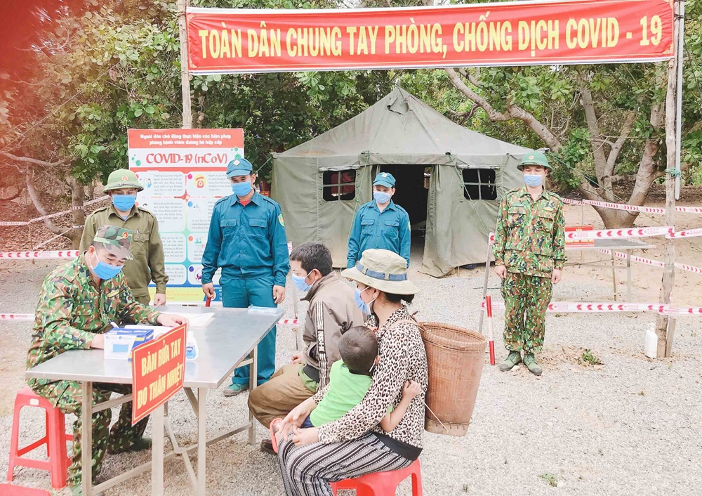 Bộ đội Biên phòng Gia Lai phát tờ rơi và hướng dẫn bà con bầu cử và phòng, chống dịch Covid-19.